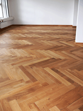 Holzfußboden in Schachbrettmuster, hellbraune und dunkle Holzflächen.