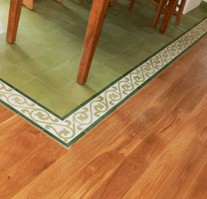 Bodenleger Service Holzboden und grüne Fliesen mit dekorativem Randmuster.