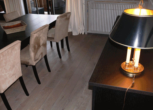 Essbereich mit Stühlen, Tisch und einer Lampe auf einem dunklen Schreibtisch.