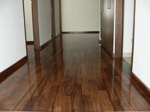 Holzboden in einem Flur mit offenen Türen auf beiden Seiten.